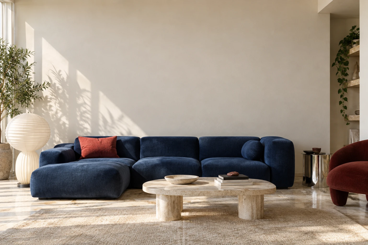 A chic modern living room with a cobalt sofa, sculptural furniture and a warm white wall